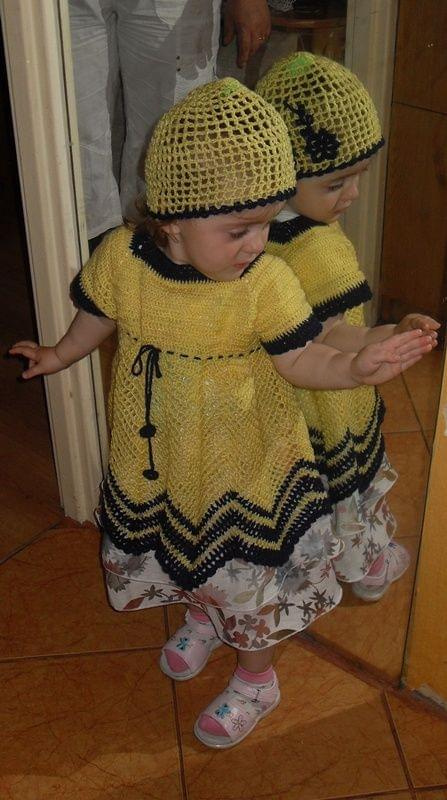 Martynka (2lata) w sukience i czapeczce w lustrze